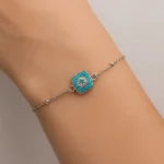Kadın bileğinde turkuaz taşlı gümüş kare bileklik